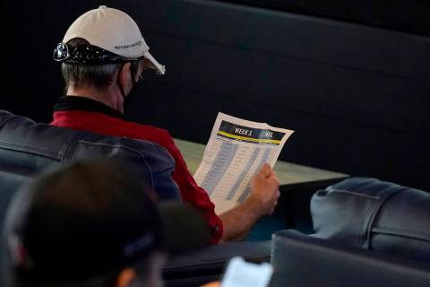 A customer looks over NFL matchups inside FanDuel Sportsbook inside the Footprint Center, Thurs ...