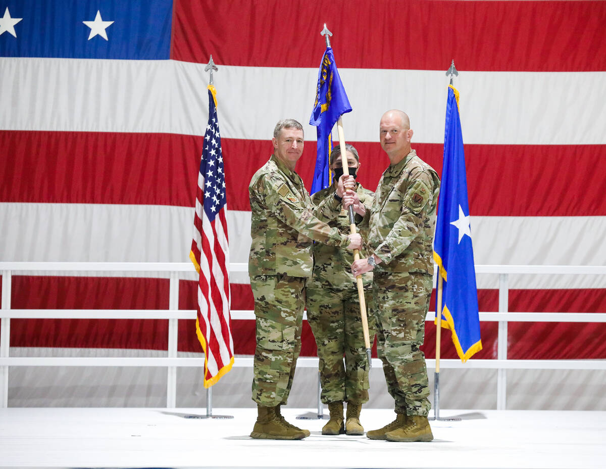 Brig. Gen. Evan Pettus, left, hands the wing guide-on flag for the 99th Air Base Wing to Col. J ...