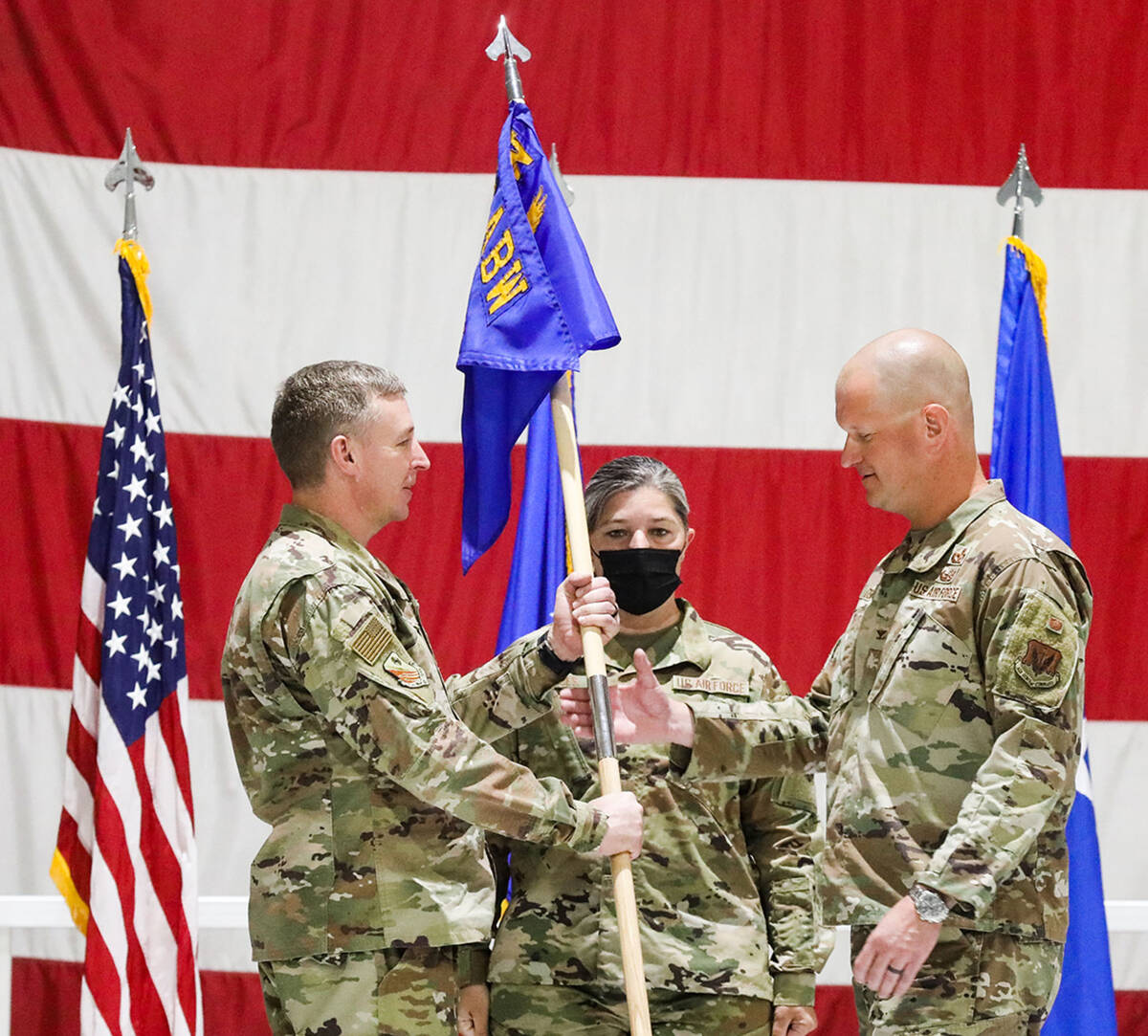 Chief Master Sgt. Jodi Snyder looks on as Brig. Gen. Evan Pettus, left, hands the wing guide-on ...