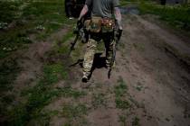 A civilian militia man holds a shotgun and a rifle during training at a shooting range in outsk ...