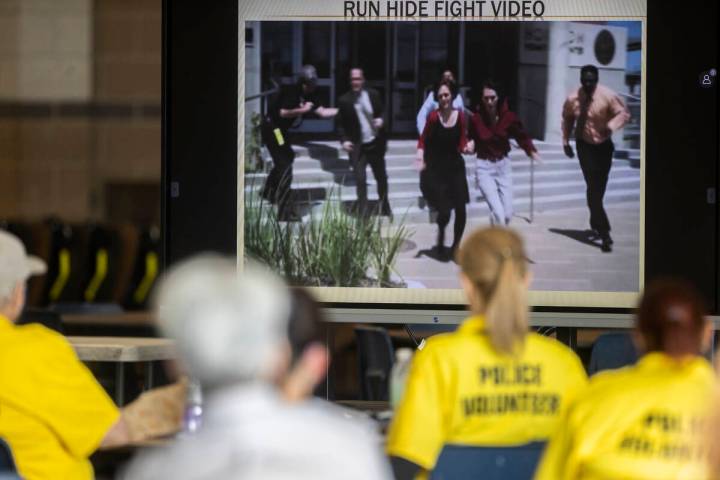 Attendees watch a video addressing active shooter tactics at Spring Valley High School on Tues ...