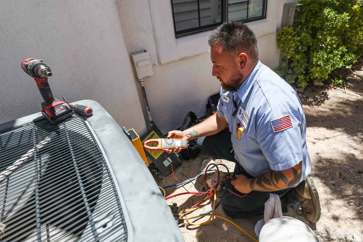 Service technician with Sahara Air Conditioning & Heating Jeremy Rojas repairs an air condi ...