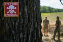 A notice warning about land mines is attached to a tree as a Ukrainian specialized team searche ...
