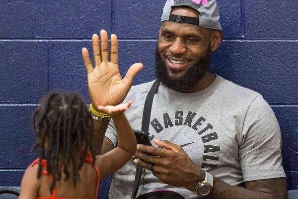 Los Angeles Lakers power forward LeBron James high fives his daughter Zhuri before the start of ...