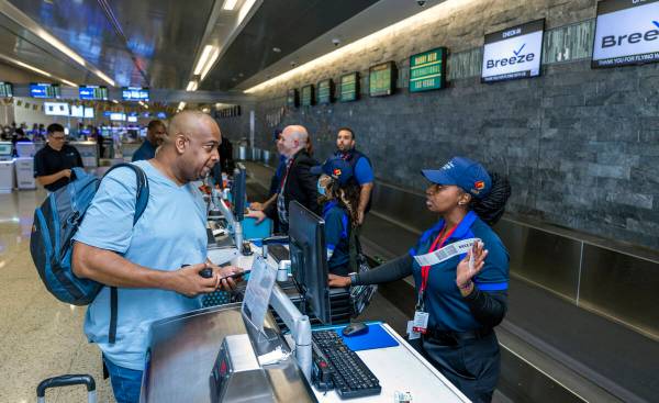 Passenger Antoine Scott, left, of Las Vegas talks with Breeze Airways ticketing agent Treyona C ...