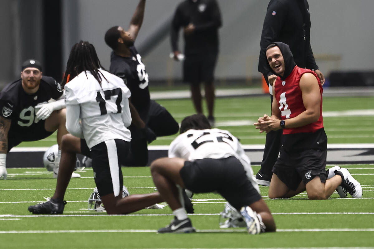 Raiders quarterback Derek Carr, right, shares a laugh with wide receiver Davante Adams (17) as ...