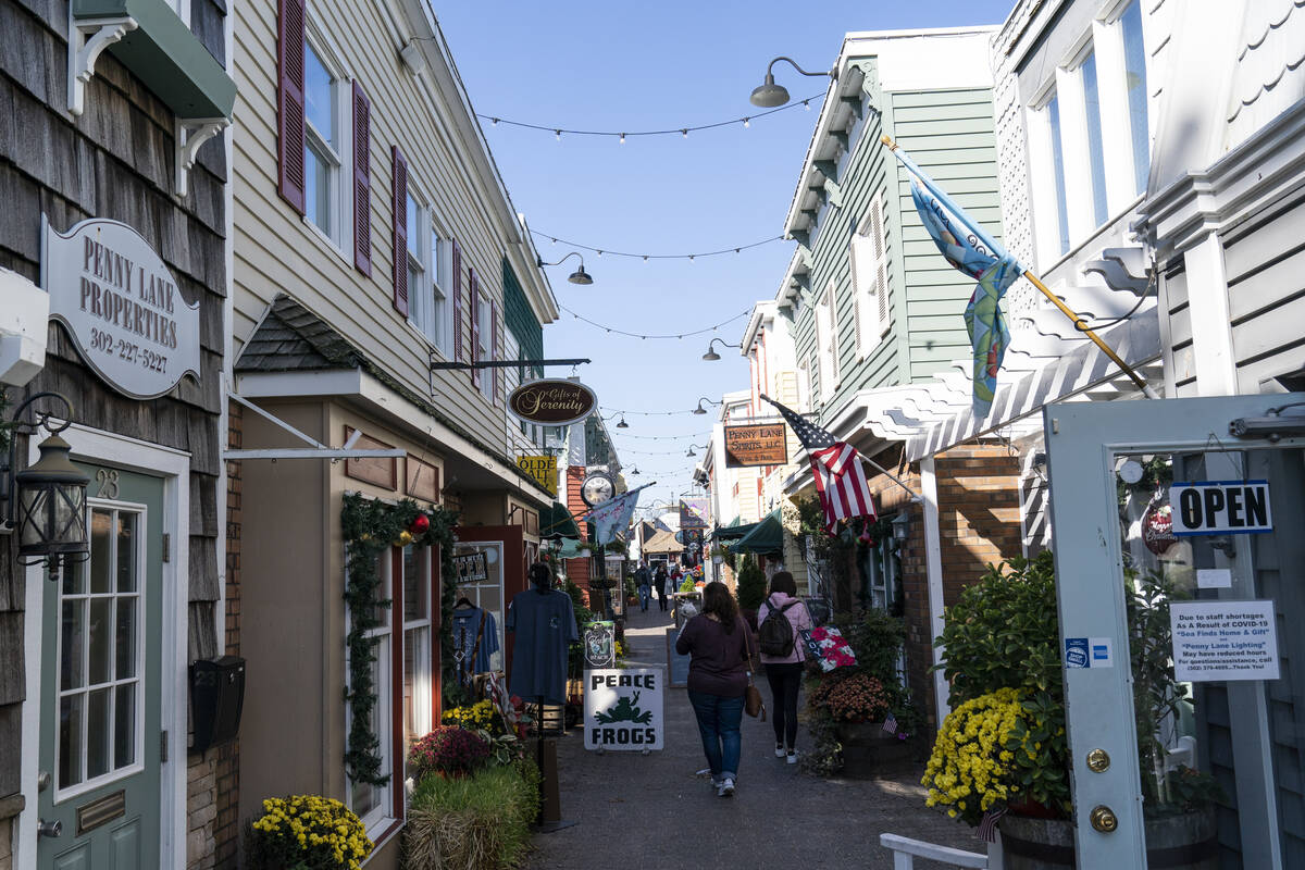 FILE - People walk by shops Nov. 13, 2020, in Rehoboth Beach, Del. The Friday June 10, 2022, re ...