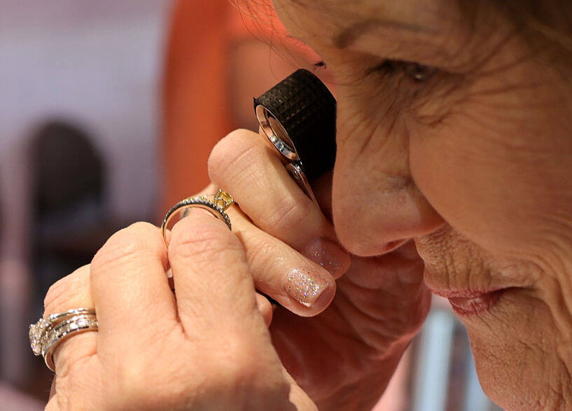 Joyce Gahn of Gems by Joyce in Sun City, Ariz. uses a jewelry loupe to check out a ring during ...