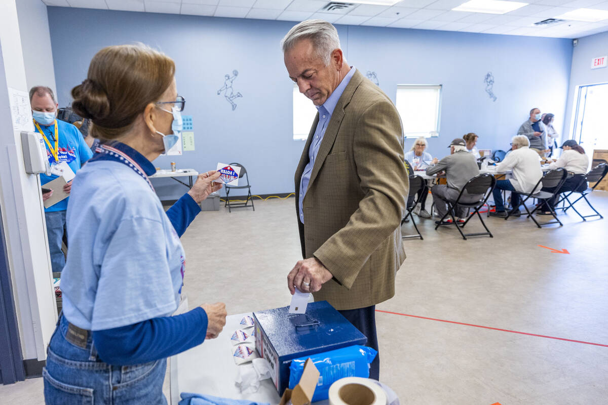 Sheriff Joe Lombardo inserts his vote card while getting a sticker after voting during the Neva ...
