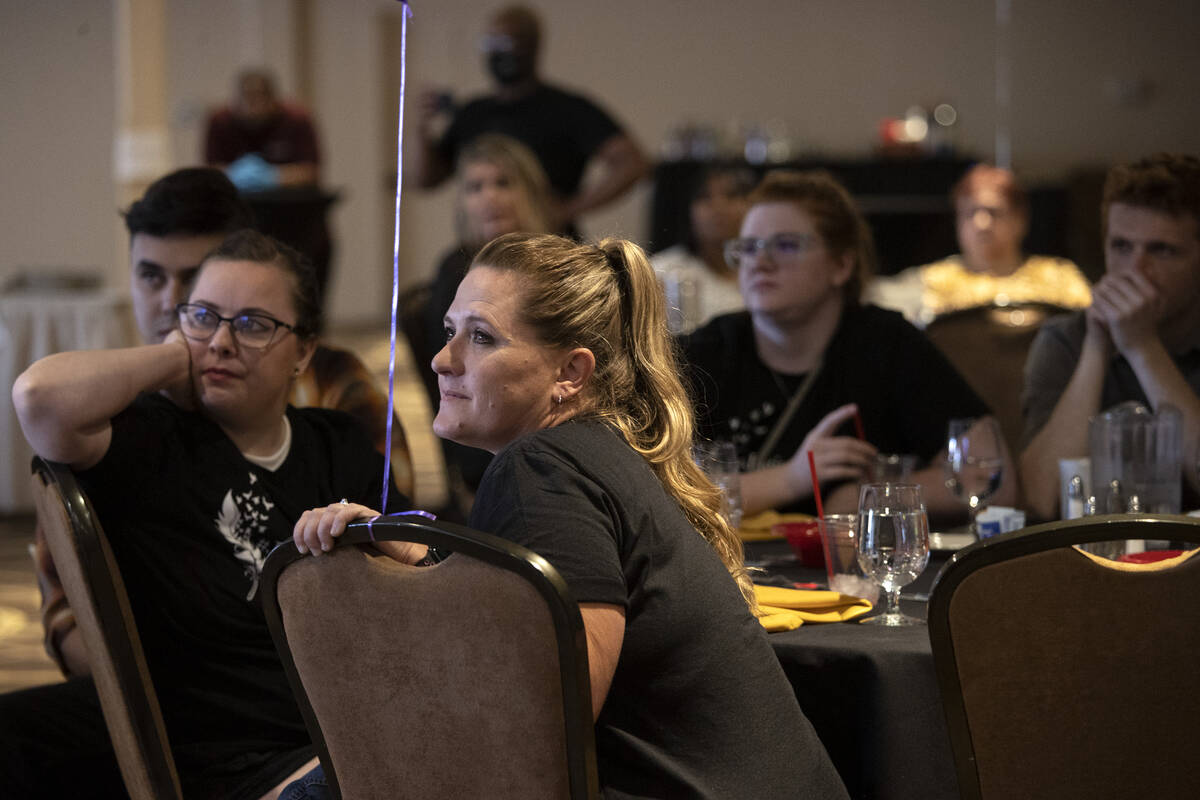 Angelena Fisher, second from left, watches a slideshow of old photos during a memorial service ...