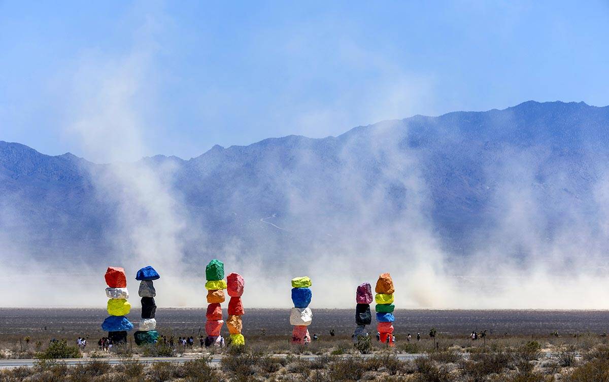 Seven Magic Mountains with giant dust clouds coming off of the dry lake bed as a backdrop while ...