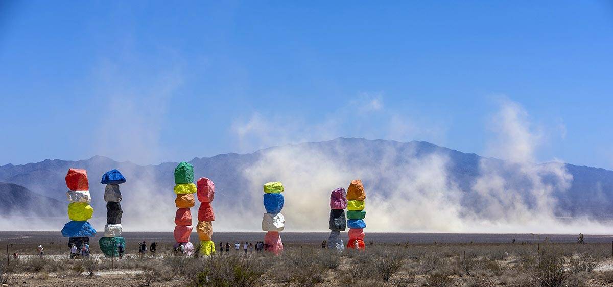 Seven Magic Mountains with giant dust clouds coming off of the dry lake bed as a backdrop while ...