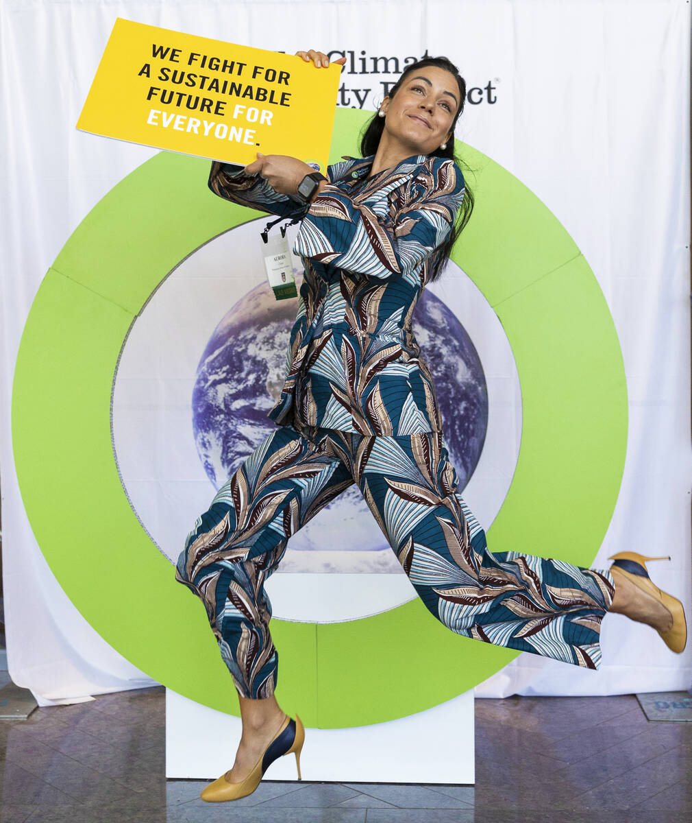 Aurora Chiste, from Washington, D.C., takes a photo holding a sustainability sign at the Climat ...
