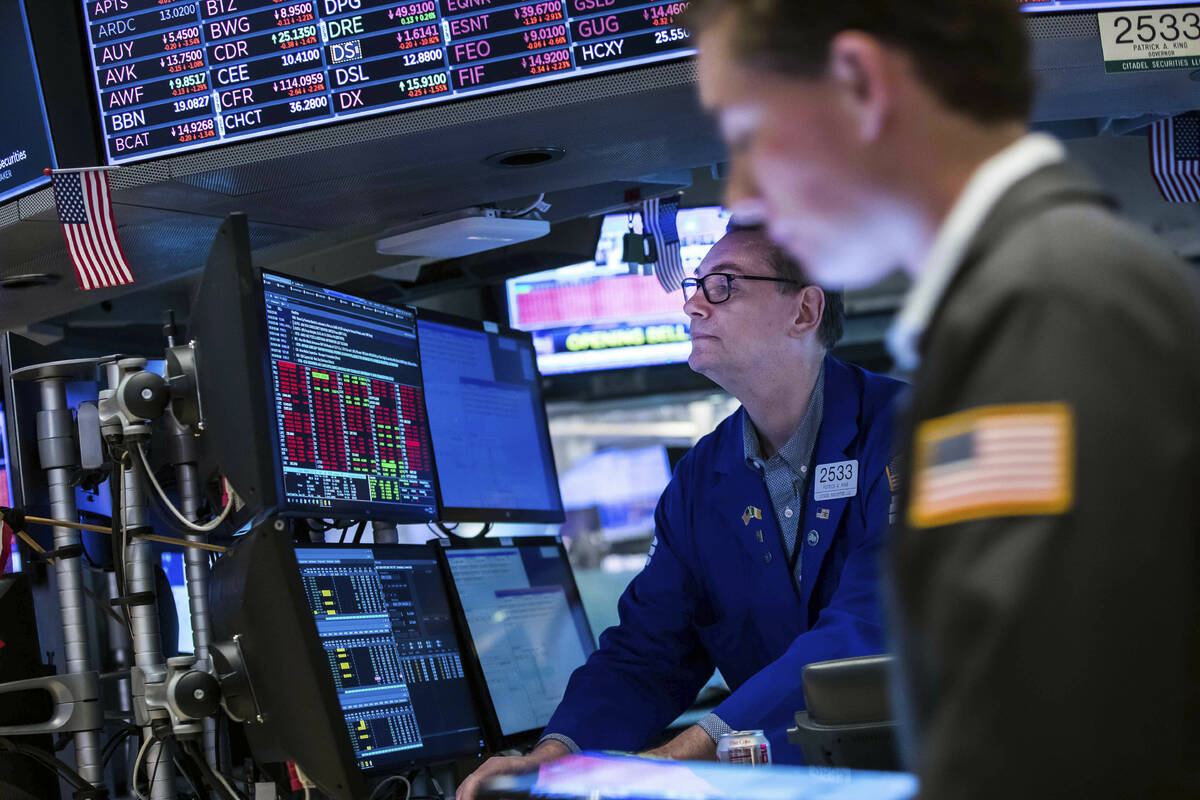 In this photo provided by the New York Stock Exchange, specialist Patrick King, left, works a h ...