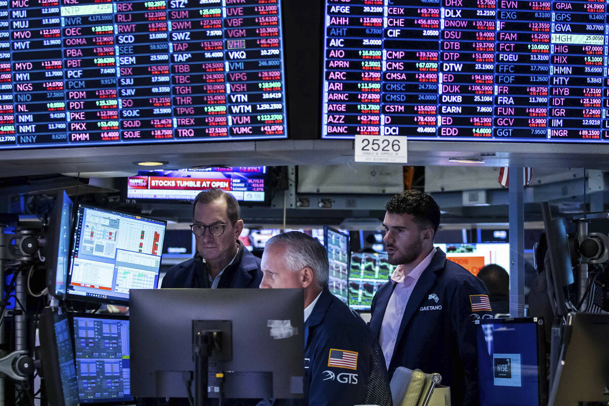 In this photo provided by the New York Stock Exchange, a trio of specialists work at a post on ...