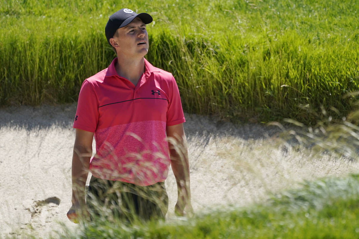 Jordan Spieth looks toward the green, over the tall grass at the lip of a bunker, during a prac ...