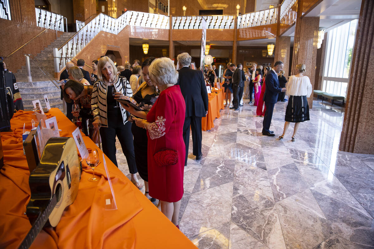 People browse the auction items during the Las Vegas Philharmonic’s fundraising event at ...