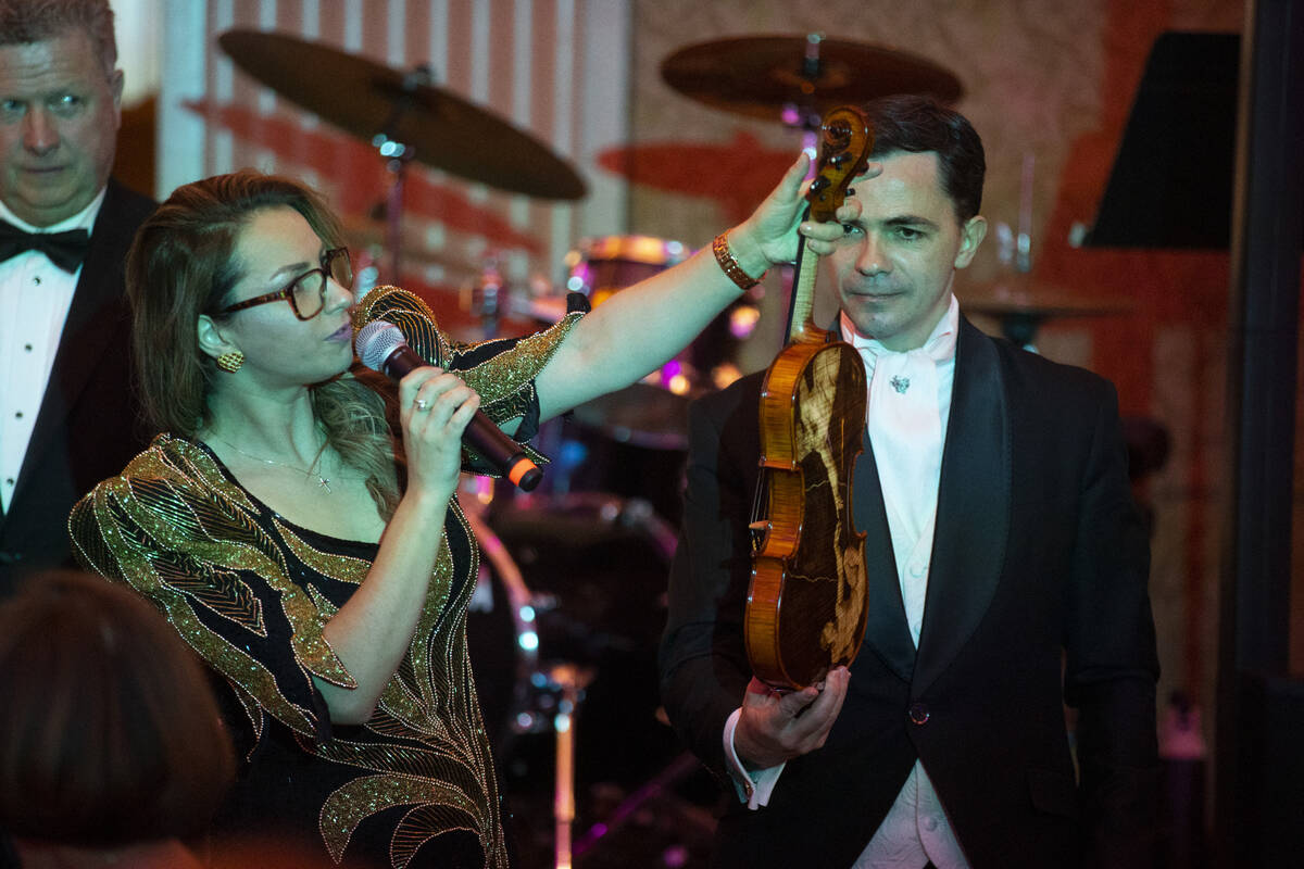 Elena Gliga and her husband Cristian auction off a violin during the Las Vegas Philharmonic&#x2 ...