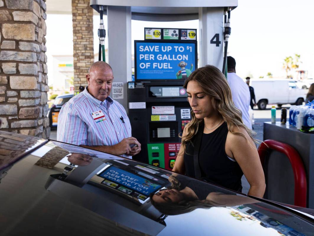 Julianne Dominguez, an intern for Golden Knights foundation, pumps gas to a customer as Bob Kel ...