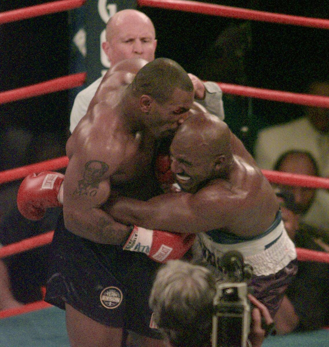 FILE - This June 28, 1997, file photo shows Mike Tyson biting into the ear of Evander Holyfield ...