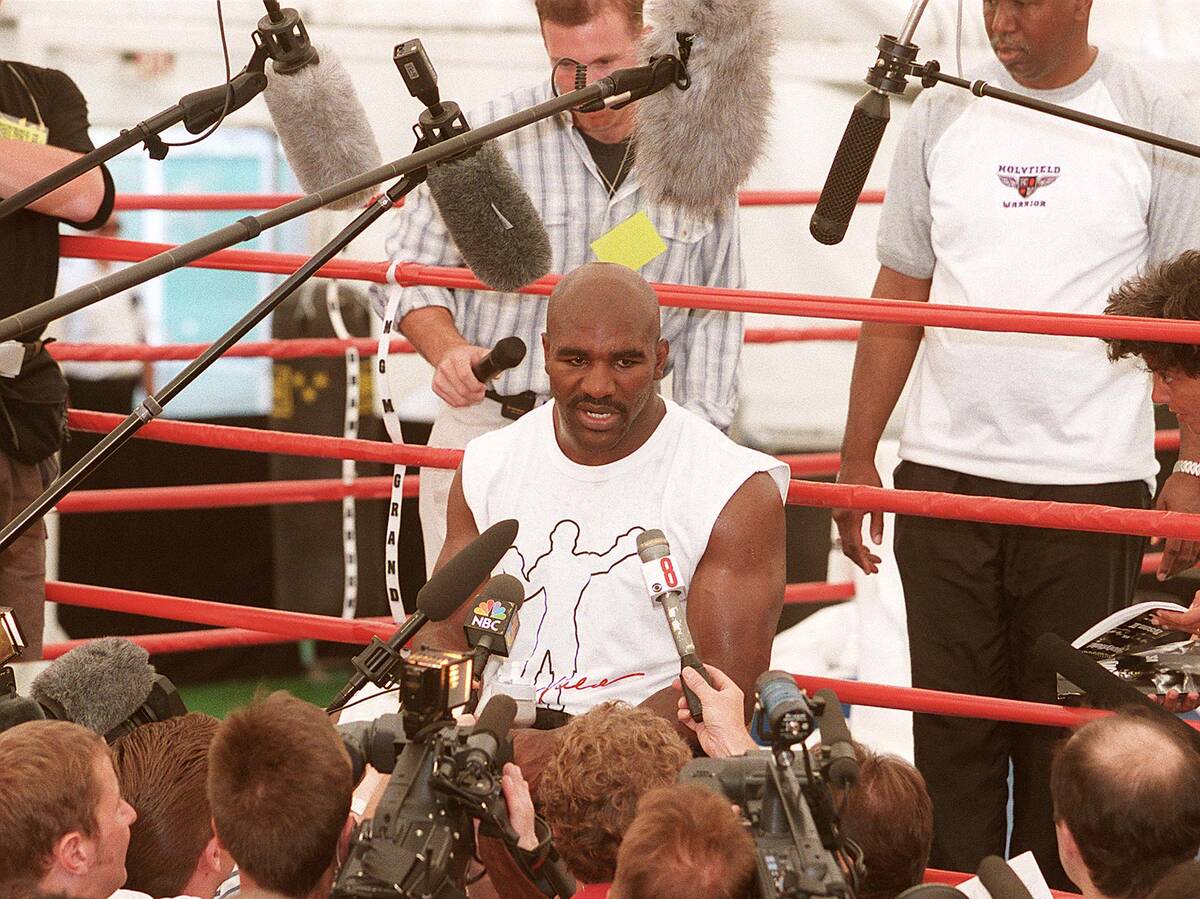 WBA Heavyweight Champion Evander Holyfield is surrounded by members of the press following a wo ...