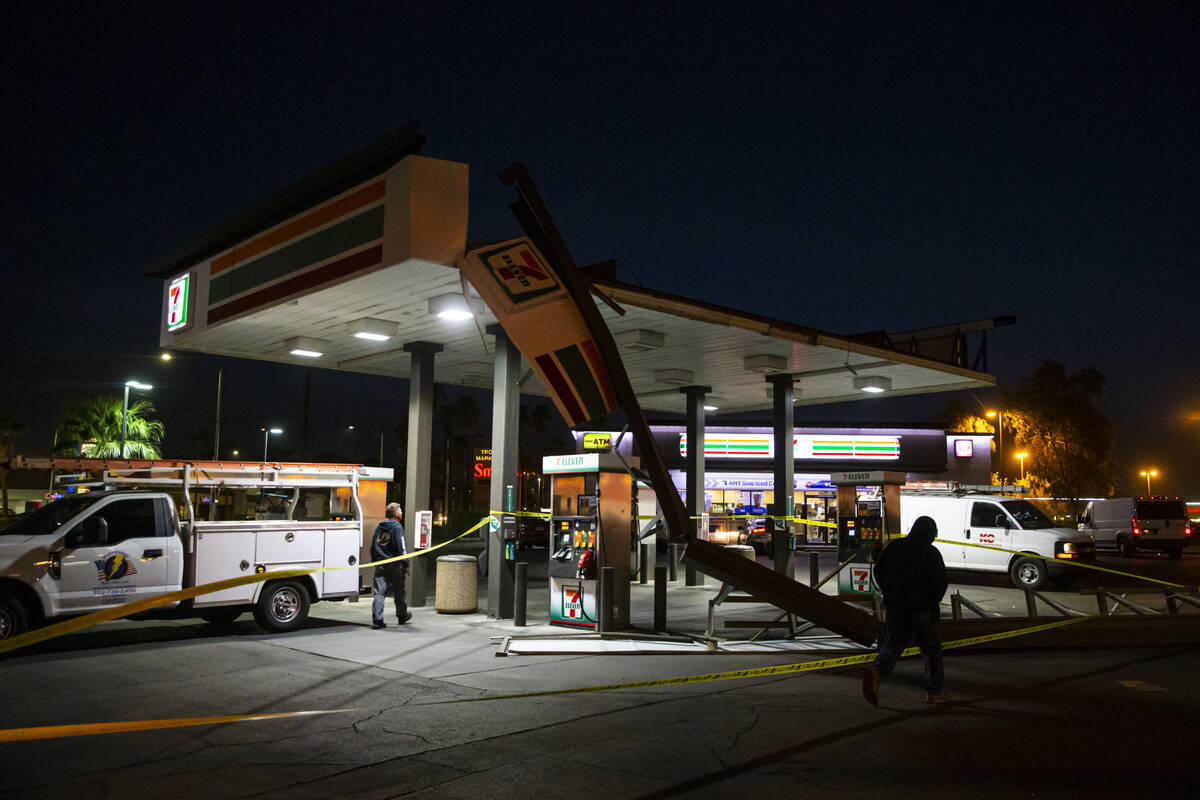 Electrical workers check on a 7-Eleven gas station that was damaged by winds on Monday, April 1 ...