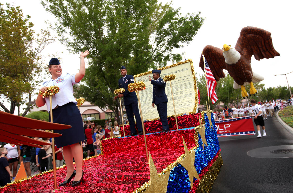 U.S. Air Force Master Sgt. Lisa Deal, left, waves from a float while riding in the 2011 Summerl ...