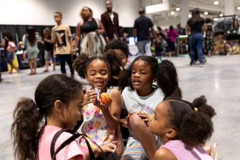 Tehani White, left, Phoenix Lamy, Wonder Lamy and Luna Lamy play with toys they got during a Ju ...