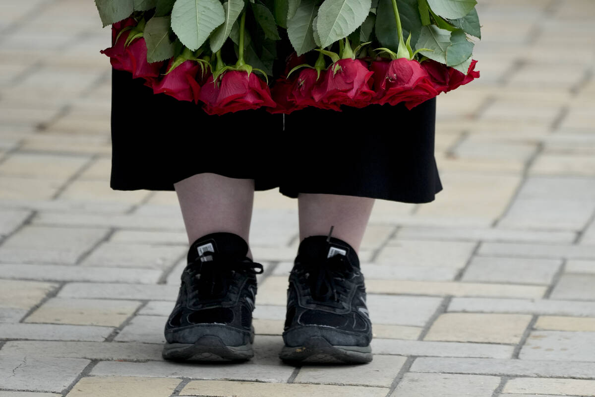A woman holds flowers during the memorial service of activist and soldier Roman Ratushnyi in Ky ...