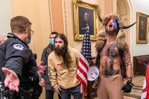 Supporters of President Donald Trump, including Jacob Chansley, right with fur hat, are confron ...
