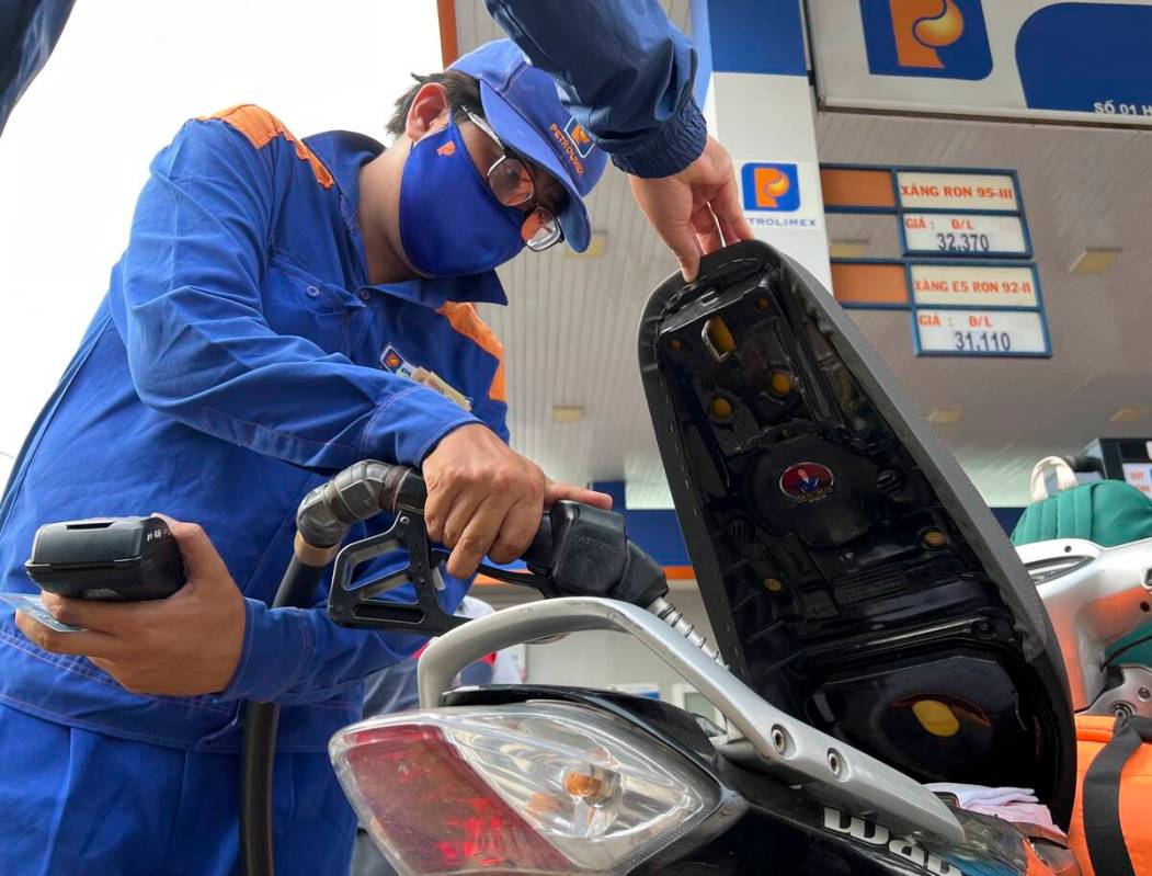 An attendant pumps gas into a motorcycle in Hanoi, Vietnam Sunday, June 19, 2022. Across the gl ...