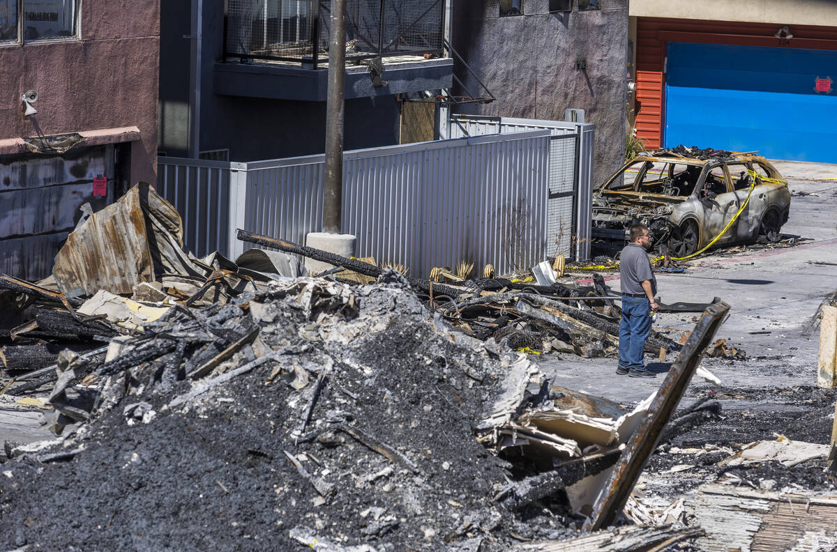 A man looks to the damage within the Urban Lofts Townhomes property where fire originated from ...