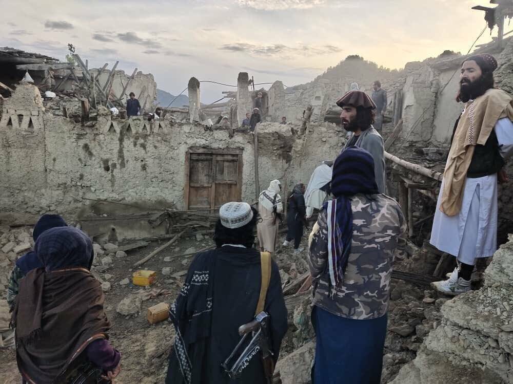 In this photo released by a state-run news agency Bakhtar, Afghans look at destruction caused b ...