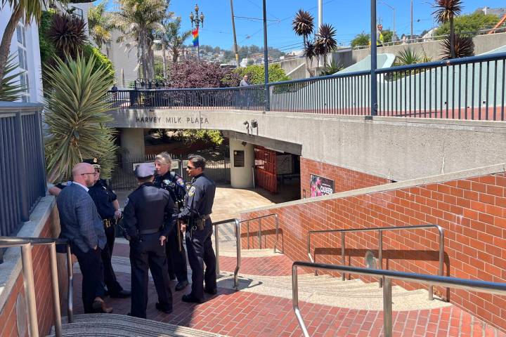 Police personnel confer outside the entrance to the Castro Muni Metro station following a shoot ...