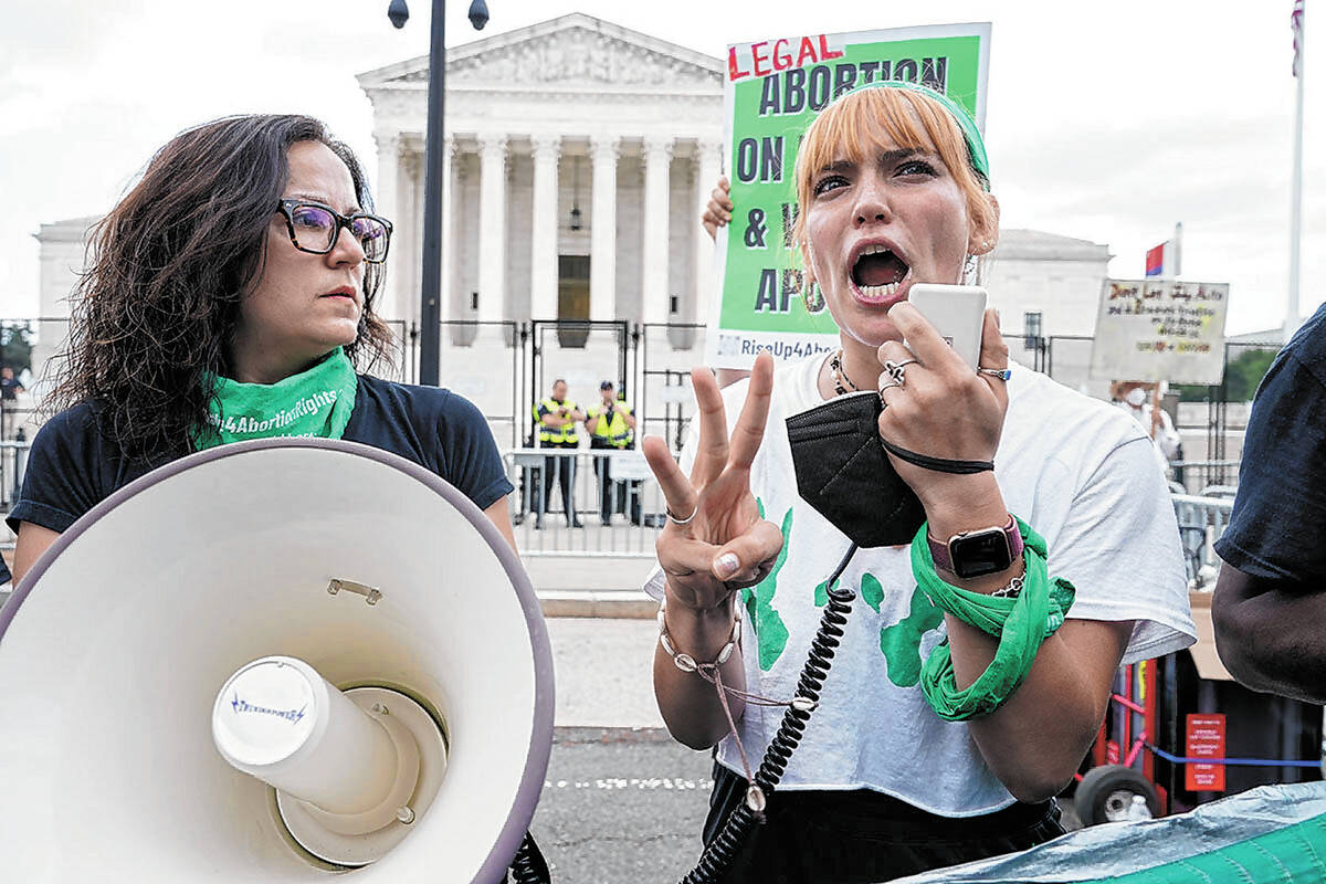 Abortion-rights activists react outside the Supreme Court in Washington, Friday, June 24, 2022. ...