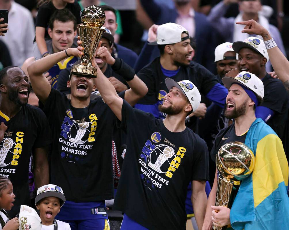 Golden State Warriors' Stephen Curry holds the MVP trophy as Klay Thompson holds the Larry O'Br ...