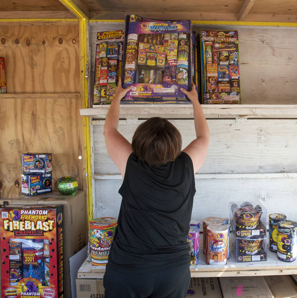 Shellie Moskos unpacks fireworks as she helps set up her organization's Phantom Fireworks stand ...