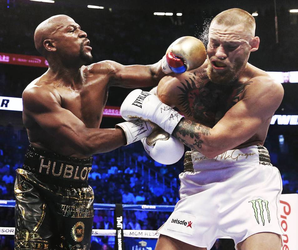 Floyd Mayweather, left, lands a left hook on the jaw of Conor McGregor on Saturday, Aug 26, 201 ...