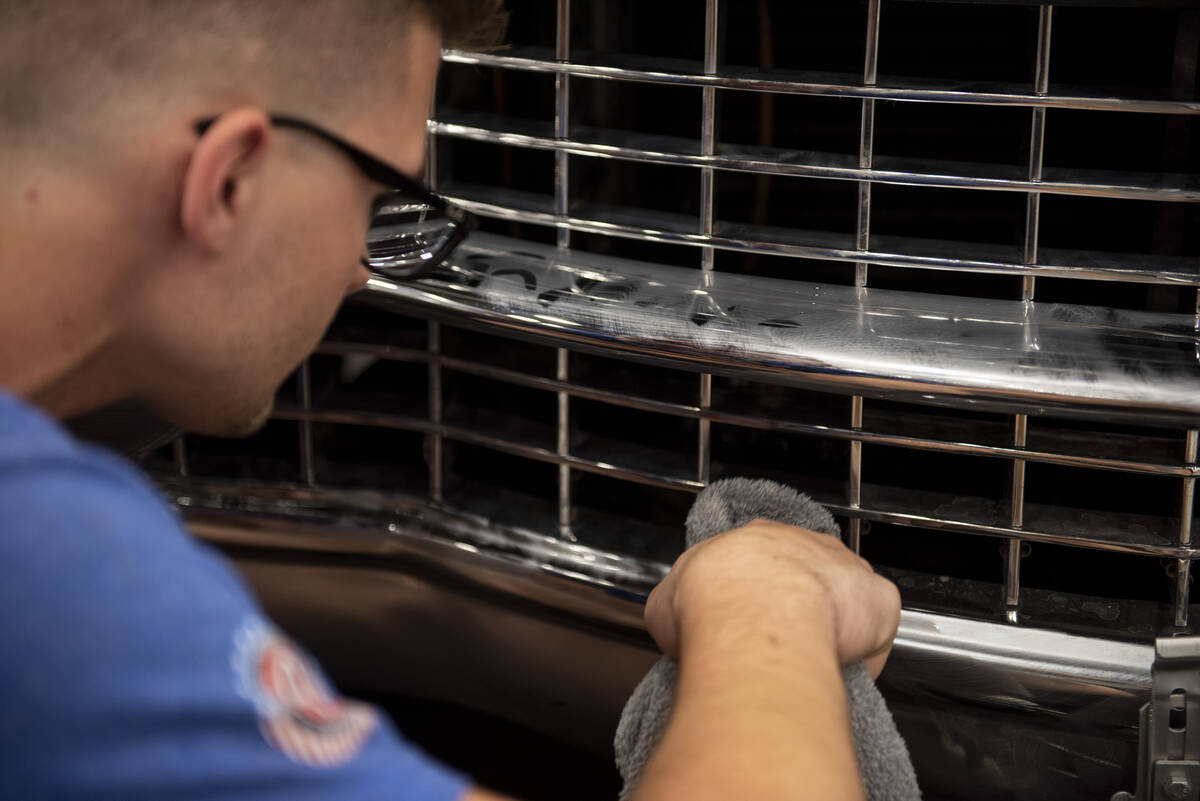 Cole McClure of Indiana details a 1955 Cadillac Coupe during the set-up for the Barrett-Jackson ...