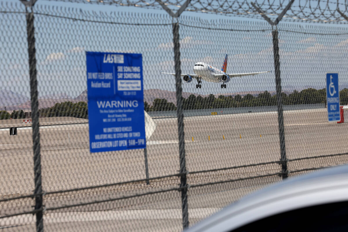 A plane lands at the Harry Reid International Airport viewing area on Sunset Road in Las Vegas ...