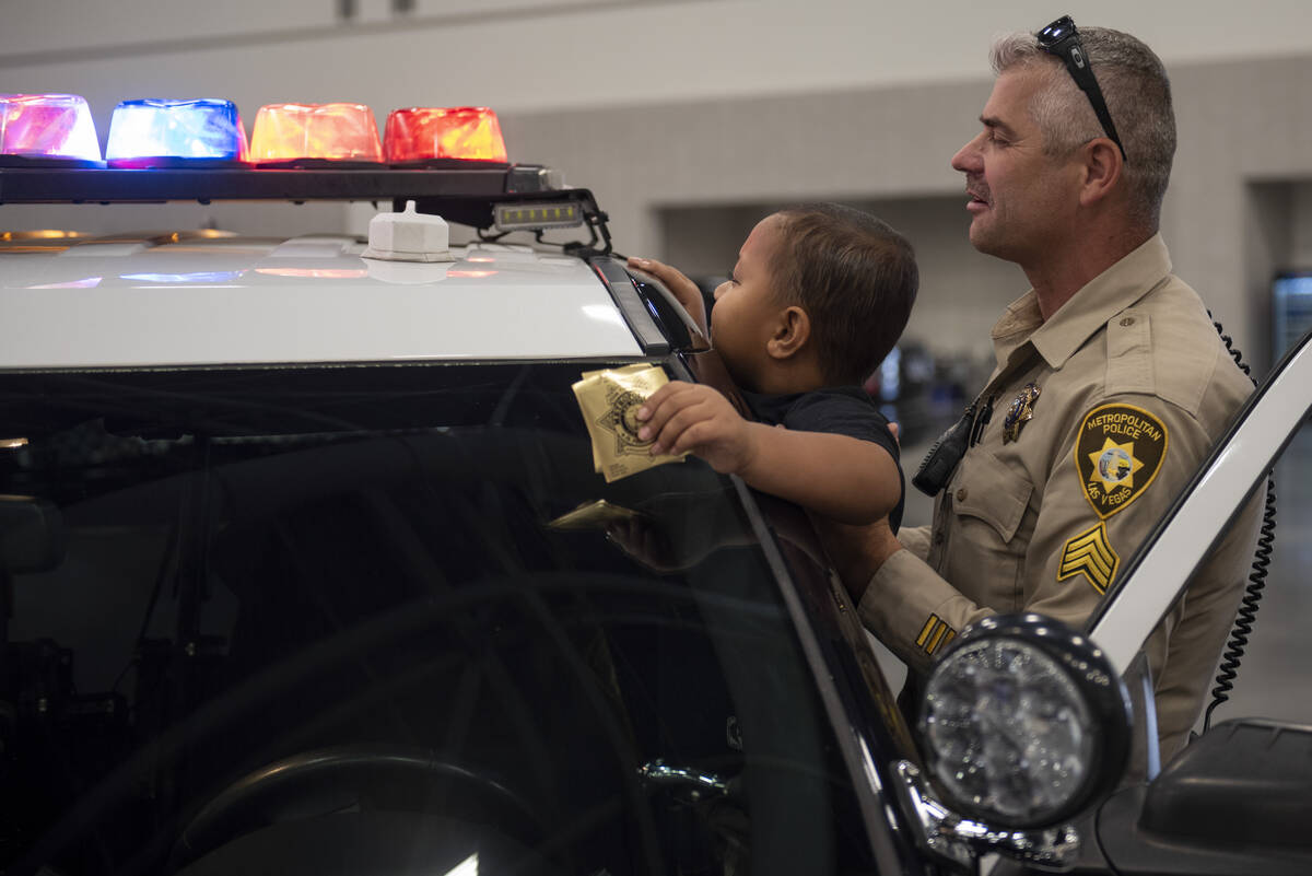 Metro Police Sargent Mark Zemsta shows Sean Moeileolo, 6, the lights on a police cruiser during ...