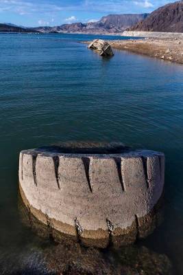 A WWII-era landing craft used to transport troops or tanks, and large tire nearby, are being re ...