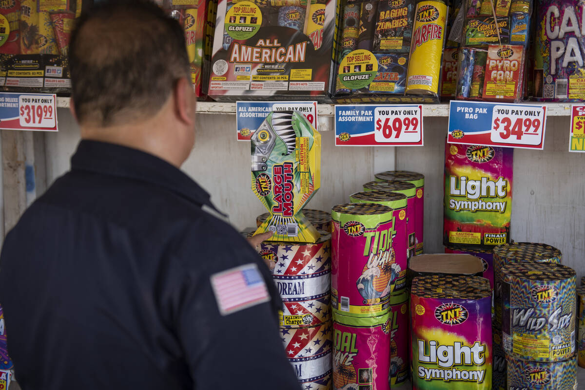 Clark County Fire Inspector Martin Casillas points out the Safe-N-Sane label during a fireworks ...