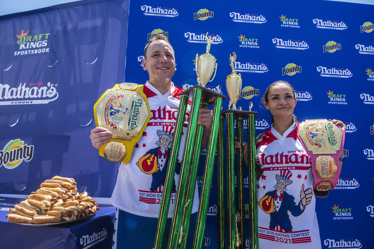 Winners Joey Chestnut and Michelle Lesco pose with their championship belts and trophies at the ...