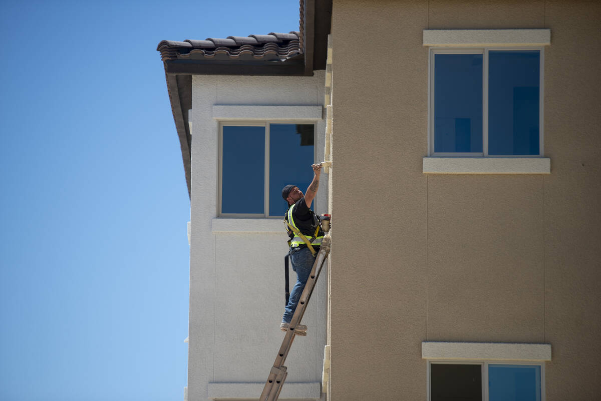 Workers put the finishing touches on a building at the Decatur Commons affordable housing compl ...