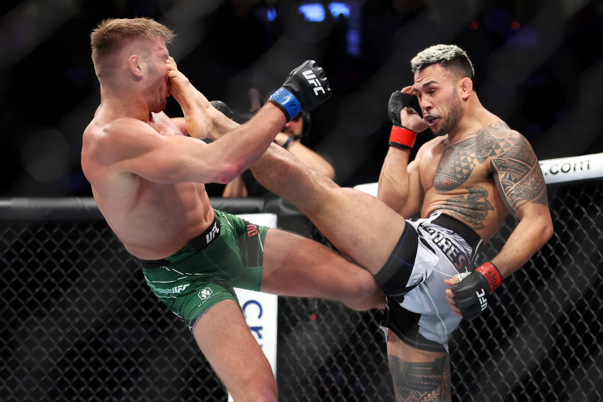 Dricus Du Plessis, left, takes a kick to the face against Brad Tavares during the third round i ...