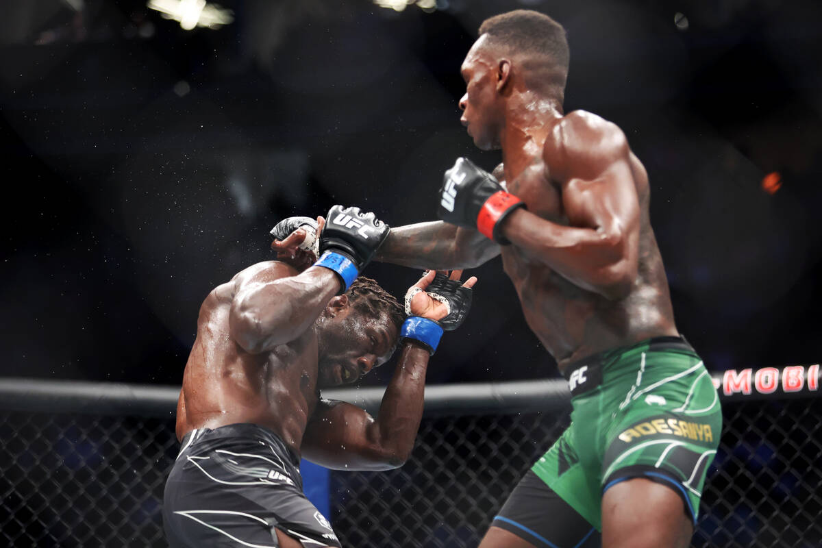Israel Adesanya, right, throws a punch against Jared Cannonier during the fourth round of a mid ...