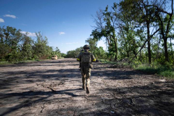 A Ukrainian serviceman changes his position at the frontline near Kharkiv, Ukraine, on Saturday ...