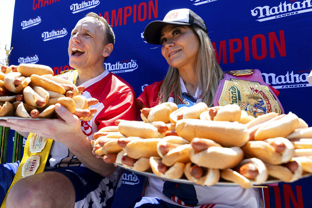 Joey Chestnut and Miki Sudo pose with 63 and 40 hot dogs, respectively, after winning the Natha ...