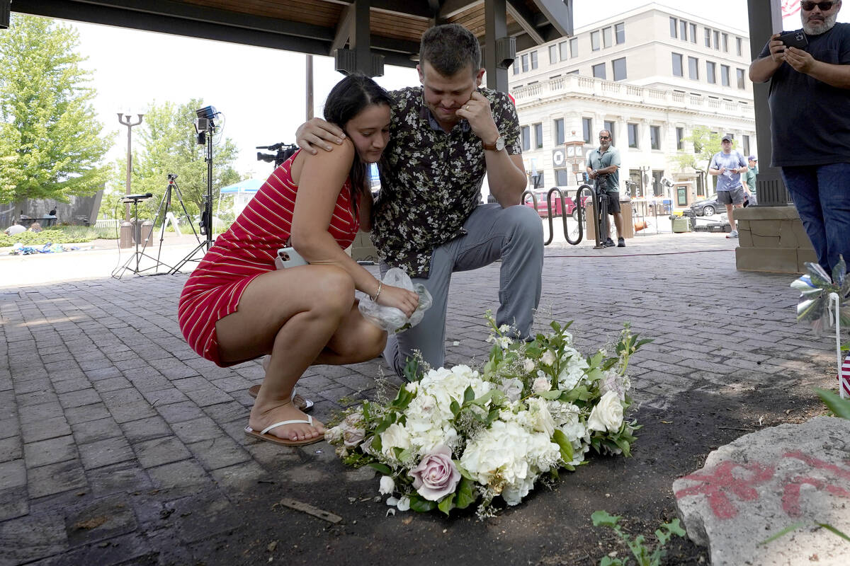 Brooke and Matt Strauss, who were married Sunday, pause after leaving their wedding bouquets in ...